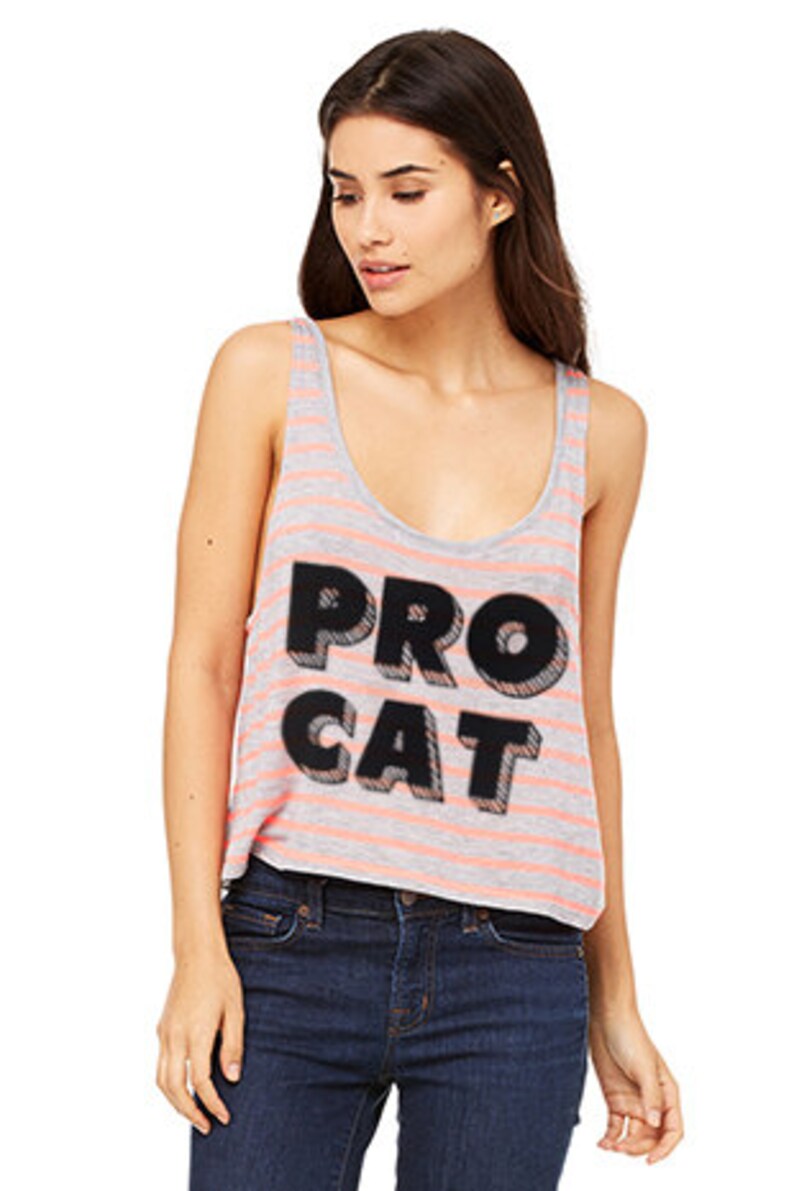 Op de afbeelding: Een grijs en roze gestreept tanktop met een zwarte grafische afbeelding met de tekst "PRO CAT" in een vetgedrukt, 3D-stijl lettertype.