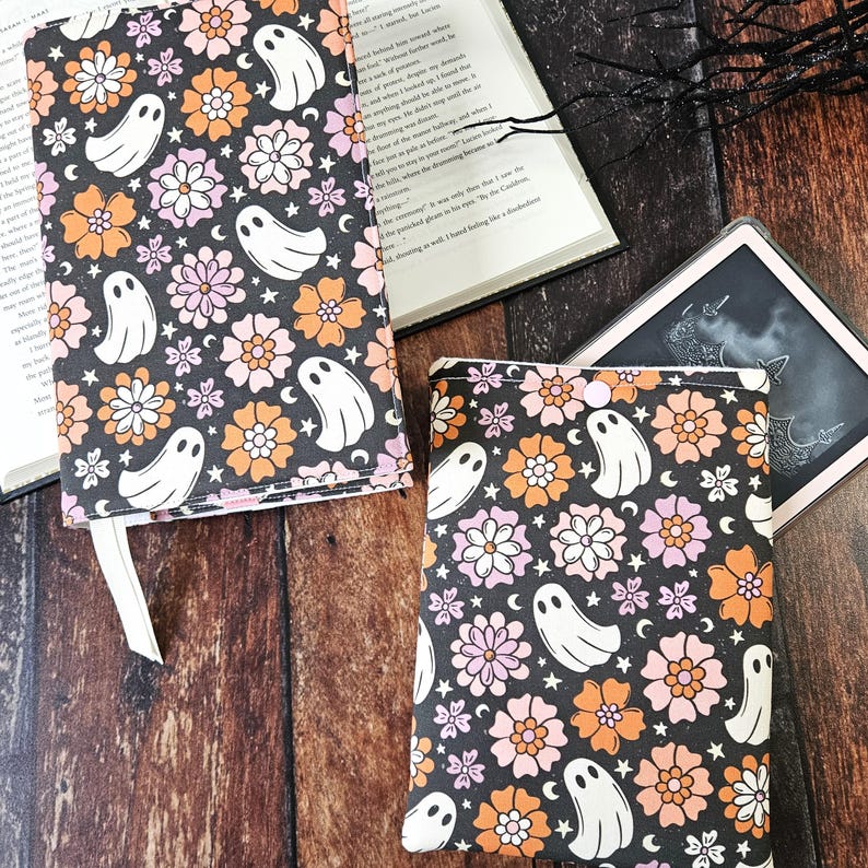 May include: Two book covers with a black background and a repeating pattern of white ghosts, orange and pink flowers, and white stars.