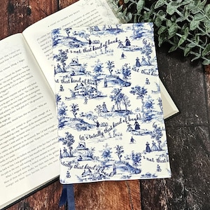 May include: A book cover with a blue and white toile pattern featuring a landscape design with figures and buildings. The cover has the text "It's not that kind of book" and "It's totally that kind of book".