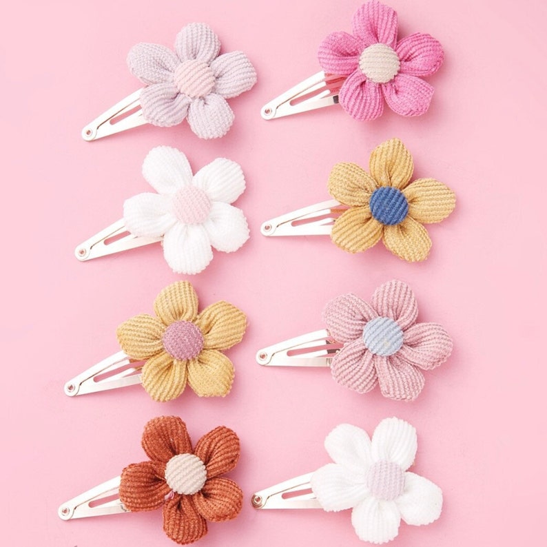 May include: Set of ten flower hair clips in various colors, including pink, white, yellow, and brown. Each clip features a fabric flower with a small button center.