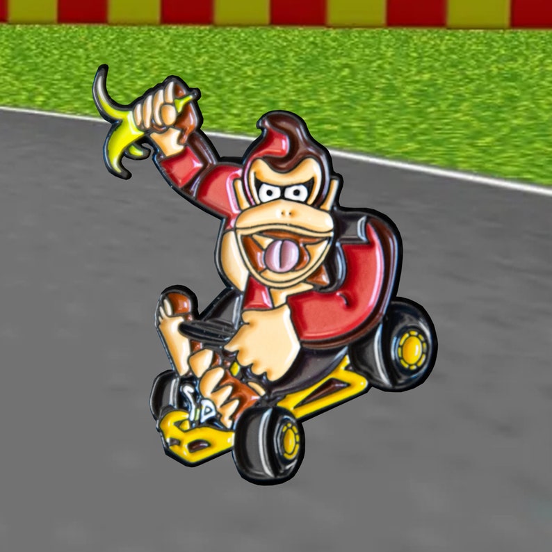 Pu&ograve; includere: Un personaggio dei cartoni animati rosso e giallo che guida un kart giallo. Il personaggio ha la pelliccia marrone, una camicia rossa e una banana in mano.