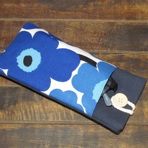 May include: A blue and white floral patterned glasses case with a navy blue flap and a wooden button closure.