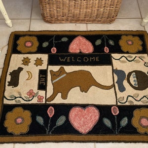 Primitive folk art hand Hooked Rug by Jean Tynan.  Sampler rug design by Marien Ham.  Measures 42” x 31”.