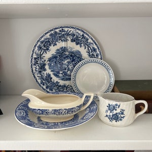 May include: A set of blue and white china dishes, including a large plate, a smaller plate, a gravy boat, and a creamer. The dishes feature a floral pattern with blue accents.