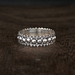 Op de afbeelding: Een zilveren ring met een parelmoerontwerp. De ring is gemaakt van sterling zilver en heeft een gepolijste afwerking.