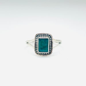 Puede incluir: Un anillo de plata con una piedra rectangular verde oscuro engastada en un marco de plata decorativo.