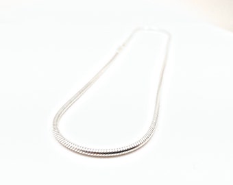 May include: A silver snake chain necklace. The chain is smooth and shiny.