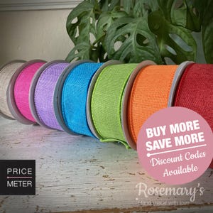 May include: A row of seven spools of textured ribbon in beige, hot pink, lavender, bright blue, lime green, orange, and red. A pink circular graphic overlay features the white text: BUY MORE SAVE MORE Discount Codes Available.