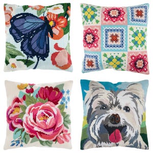 May include: Four decorative throw pillows with needlepoint designs. One pillow features a blue butterfly on a floral background. Another has a patchwork pattern. The third displays pink and red flowers. The last pillow shows a dog's face.