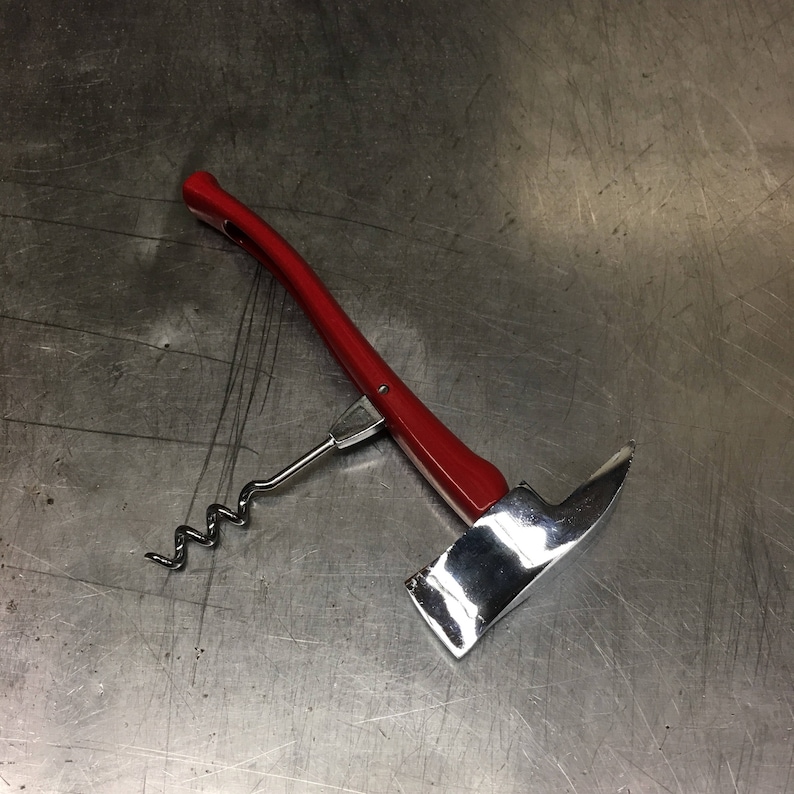 May include: A red and silver bottle opener shaped like a fire axe. The opener has a corkscrew and a lever.