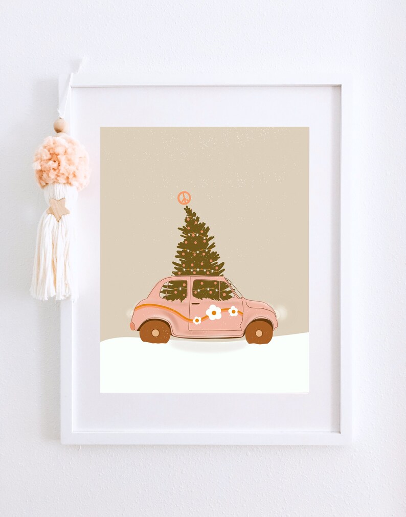 May include: A pink vintage car with a Christmas tree on top, decorated with white flowers and a peace sign. The car is driving through a snowy landscape.