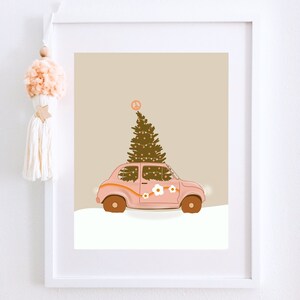 May include: A pink vintage car with a Christmas tree on top. The car has white flowers and a peace sign on the side. The background is a light brown color.