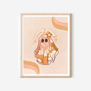 May include: A digital illustration of a ghost wearing a groovy floral pattern in shades of orange, pink, and white. The ghost has a flower on its head and the text "groovy ghoul" is written above it.
