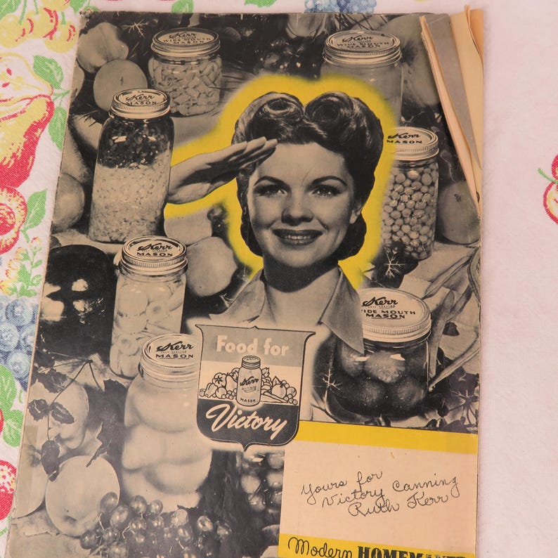 May include: Vintage Kerr Mason canning guide featuring a woman saluting, surrounded by jars of preserved food. The cover has the text "Food for Victory" and "Yours for Victory Canning Ruth Kerr". The background is a mix of black, white, and yellow.