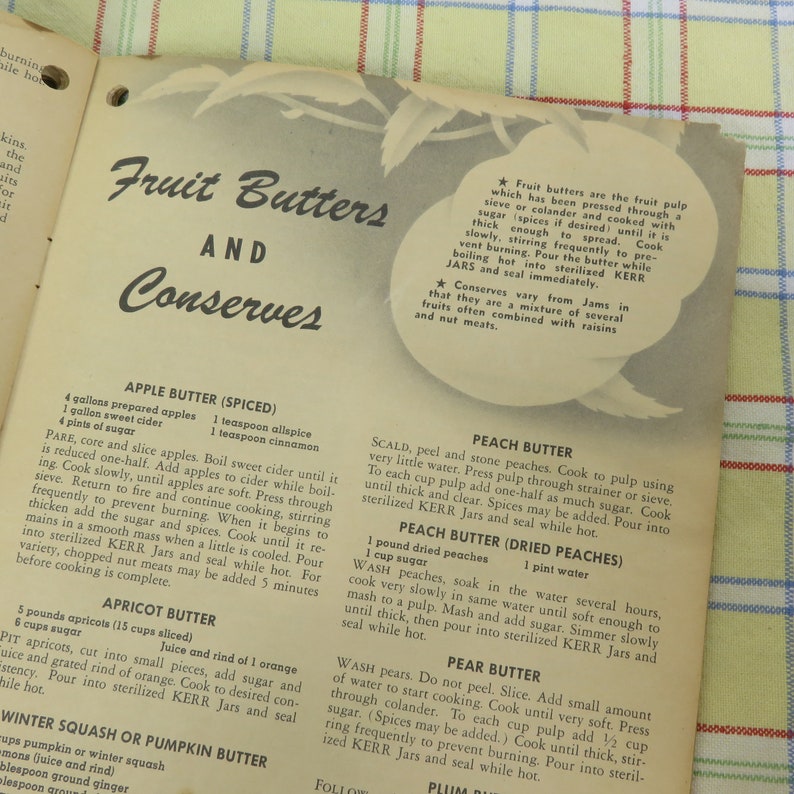 May include: A vintage cookbook page titled "Fruit Butters and Conserves" with recipes for apple, apricot, peach, and pear butter. The page features text and a decorative leaf illustration.