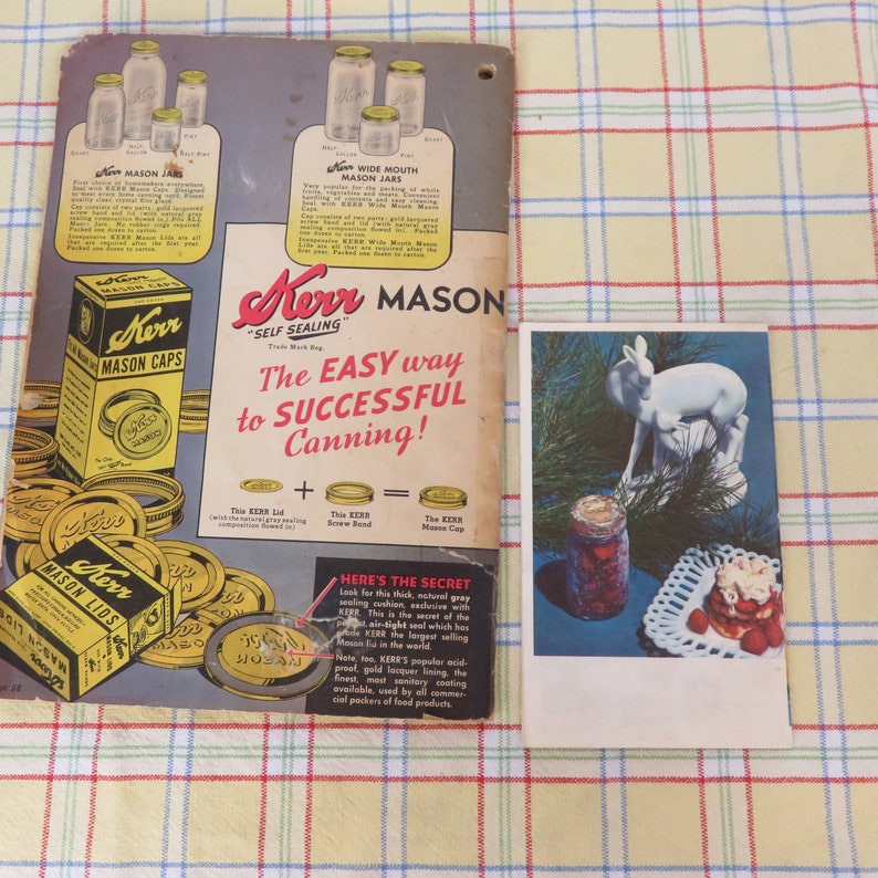 May include: Vintage Kerr Mason jar advertisement and a postcard featuring a white deer statue and a jar of preserves. The advertisement showcases various jar sizes and Kerr Mason Caps. The postcard includes a jar of preserves and a dessert.