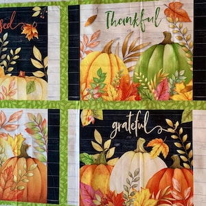 May include: A fabric panel featuring four rectangular sections with autumn themes, displaying pumpkins, fall leaves, and the words blessed, Thankful, and grateful. The design includes a black wood-grain background and a green leaf border.