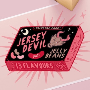 May include: A pink and black illustration of a box of "Jersey Devil Juicy Jelly Beans" with a red devil head on the front. The box has the text "Folklore Food" and "13 Flavors" on it. The text "Made in Pine Barrens, USA" is on the side of the box.