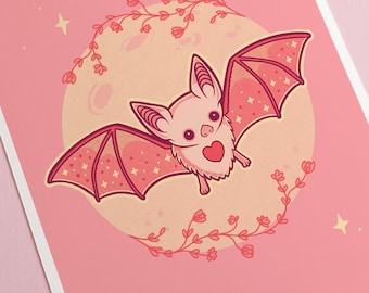 Könnte beinhalten: Eine rosa und rote Fledermaus mit einem Herzen auf der Brust fliegt vor einem gelben Mond mit rosa Blumen drumherum. Der Hintergrund ist rosa mit weißen Sternen.