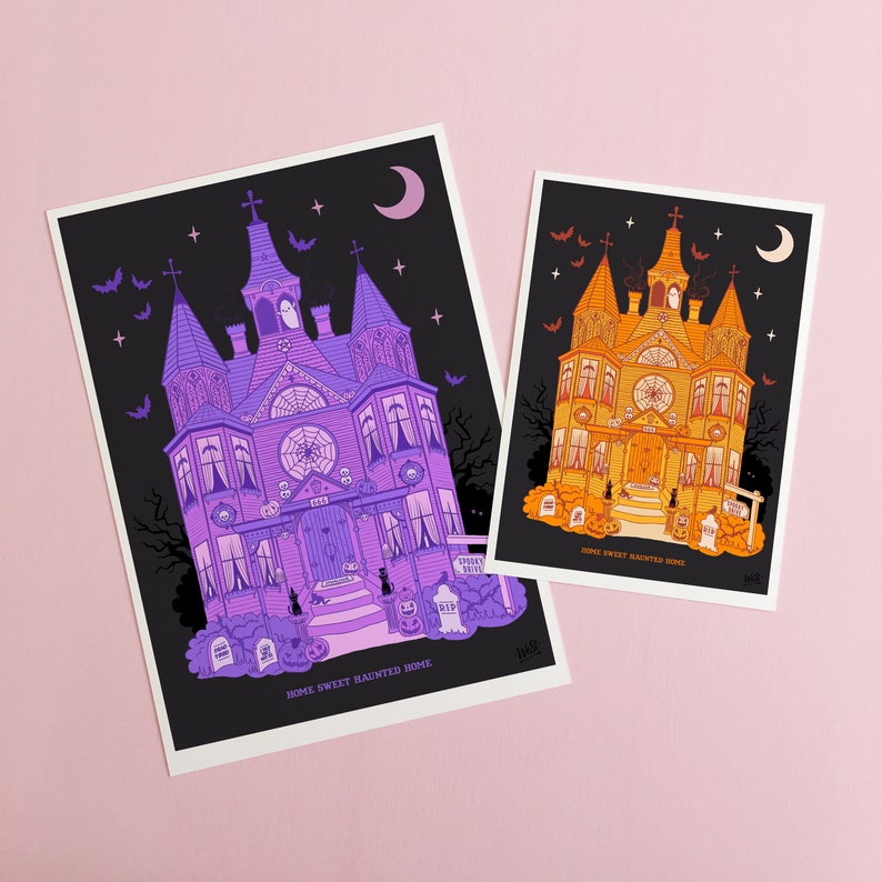May include: Two illustrated prints of a spooky, multi-colored haunted house with the text "Home Sweet Haunted Home". The house on the left is purple and the house on the right is orange.