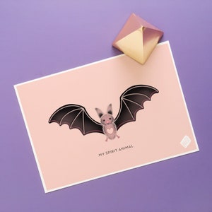 May include: A pink and brown bat with a heart on its chest is flying with its wings spread wide. The bat is on a pink background with the text "My Spirit Animal" below it.
