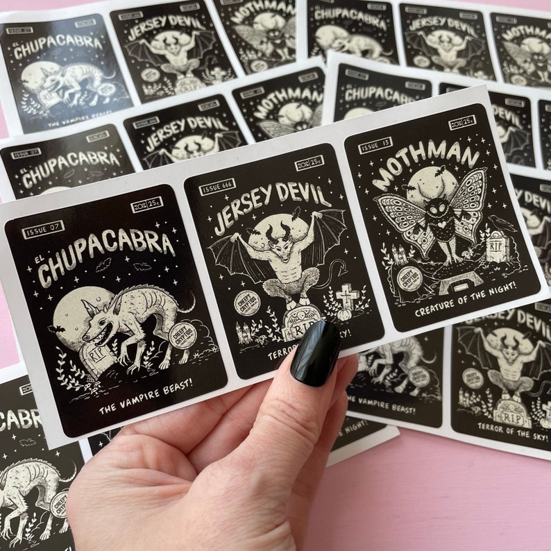May include: A set of black and white stickers featuring illustrations of mythical creatures. The stickers are labeled with the names of the creatures, including "El Chupacabra", "Jersey Devil", and "Mothman".