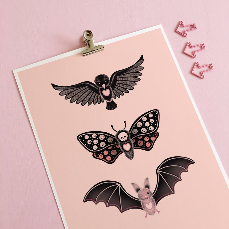 May include: A pink background with three black and pink illustrations of a bat, a butterfly, and a bird. The bat has a heart on its chest. The butterfly has a skull and crossbones pattern. The bird has a heart on its chest.