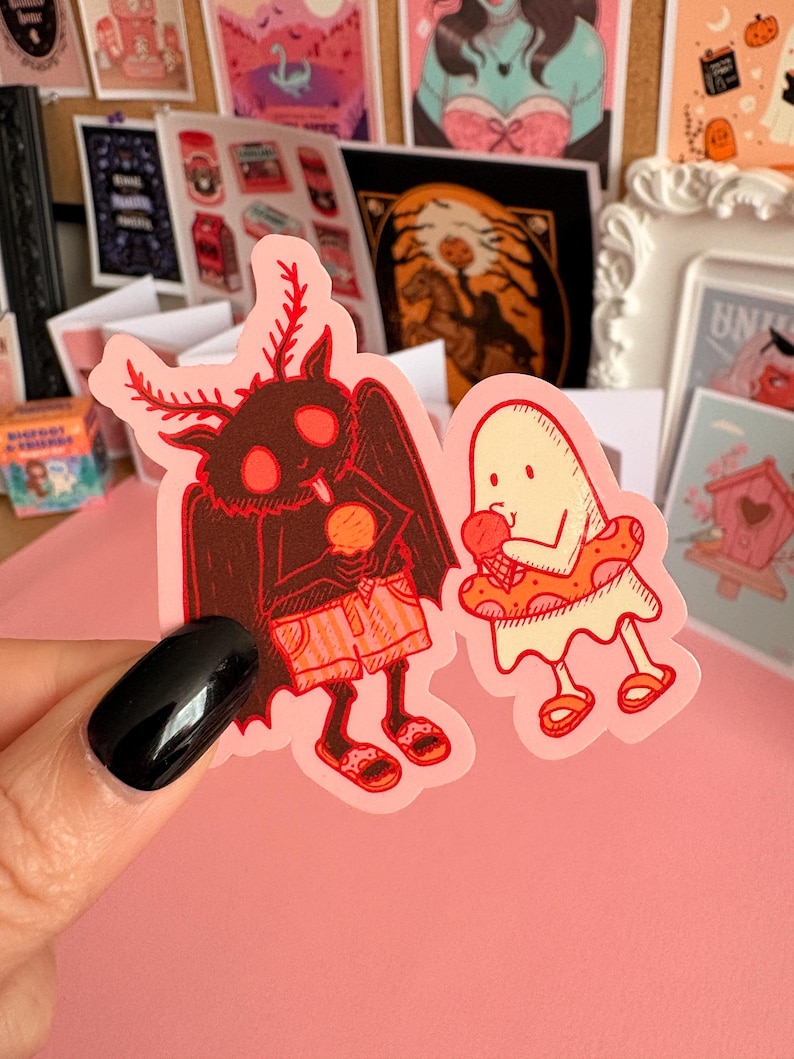 May include: A die-cut sticker featuring a dark brown moth creature with red eyes and antennae wearing orange shorts and sandals while holding an ice cream cone, next to a cream-coloured ghost wearing a red polka-dot floatie and sandals.