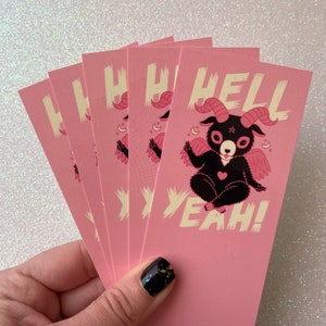 May include: A set of five pink cards with a black and white illustration of a cartoon goat with wings and the text "HELL YEAH!" printed in white.