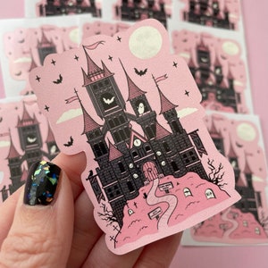 May include: Pink and black Halloween sticker featuring a spooky castle with a clock tower, bats, and a graveyard. The sticker has the text "Time Back Now" and "New Arrivals" on it.