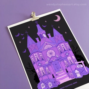 May include: A purple and black illustration of a spooky, gothic-style house with a crescent moon, bats, and stars. The house has a sign that reads "Spooky Drive" and a door with the number 666. The text at the bottom reads "Sweet Haunted Home".