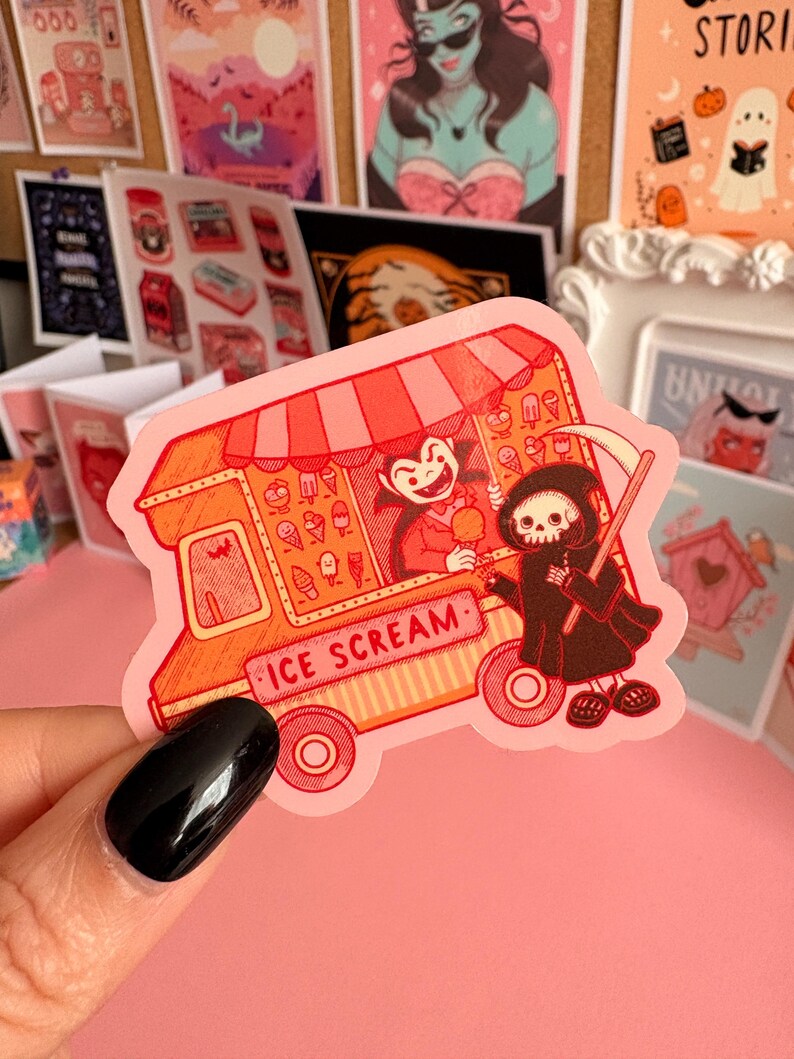 May include: A die-cut sticker featuring an orange and red ice cream truck with a striped awning. A vampire serves a scoop of ice cream to a hooded skeleton figure holding a scythe. The truck has the text ICE SCREAM printed on the side panel.