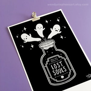 May include: Black and white illustration of a glass bottle with a label that reads "100% Pure Extract of Lost Souls". Three white ghosts are flying out of the bottle against a black background with white stars.