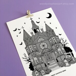 May include: A black and white illustration of a spooky haunted house with a crescent moon, bats, and a spider web. The house has a sign that says "Spooky Drive" and a tombstone that says "RIP". The text at the bottom of the image says "Sweet Haunted Home".