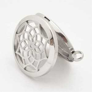 May include: Silver-toned metal locket with a circular design featuring a mandala-like pattern. The locket opens to reveal a space for essential oils or other small items.