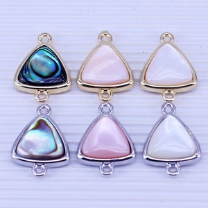 May include: Six triangle-shaped pendants with a gold or silver metal frame and a mother-of-pearl inlay. The inlays are in white, pink, and iridescent green.