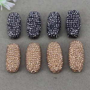 May include: Eight oval-shaped rhinestone embellishments, four are black and four are gold.