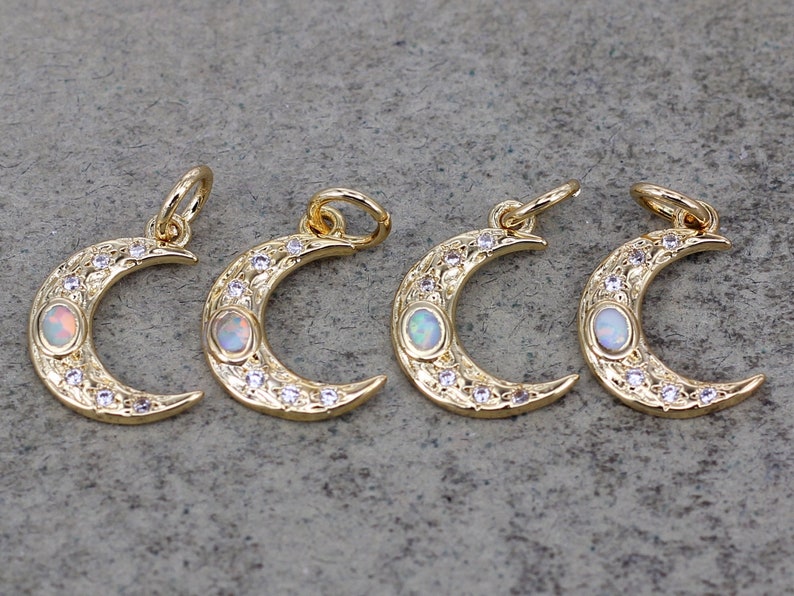 May include: Four gold crescent moon charms with opal stones and clear crystal accents. Each charm has a loop for attaching to jewelry.