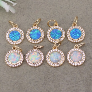 Puede incluir: Ocho colgantes dorados con centros de ópalo redondos. Cuatro colgantes tienen centros de ópalo azul y cuatro tienen centros de ópalo blanco. Cada colgante está rodeado por un anillo de pequeños cristales transparentes.