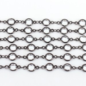 May include: A black chain with clear round crystal beads. The chain is made of metal and has a polished finish.