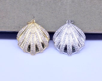 May include: Two shell-shaped pendants, one gold and one silver, both adorned with clear sparkling rhinestones.