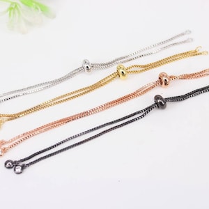 May include: Four adjustable cord bracelets with silver, gold, rose gold, and black metal accents. Each bracelet has a small clear crystal at the end of each cord.