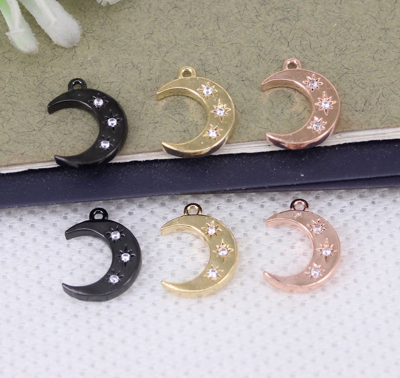 Pode incluir: Seis pingentes de lua crescente com strass. Os pingentes est&atilde;o em tr&ecirc;s acabamentos diferentes: preto, dourado e dourado rosa.