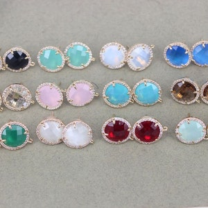May include: Assortment of 10 pairs of gold-tone earring settings with various coloured glass stones. The stones are round and have a faceted design. The settings have a loop for attaching to an earring hook.