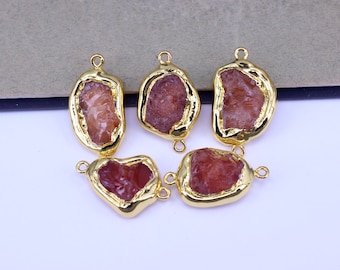 Op de afbeelding: Vijf vergulde connectoren met elk een ruwe, roze, onregelmatige edelsteen. De connectoren hebben twee lussen om aan sieraden te bevestigen.