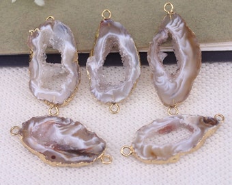 May include: Five agate stone pendants with gold-toned metal loops. The stones are white with brown and gray markings and have a natural, irregular shape.