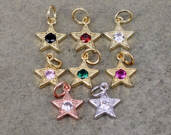 May include: Eight gold star charms with different colored gemstones in the center. The charms have a loop at the top for attaching to a necklace or bracelet.