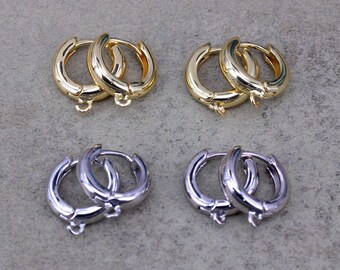 May include: Four pairs of hoop earrings, two pairs are gold and two pairs are silver. The earrings are all the same size and style.