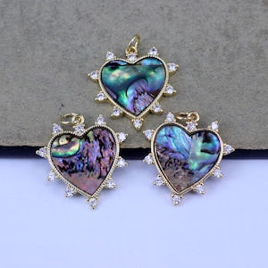 May include: Three gold heart-shaped pendants with a iridescent abalone shell inlay and clear crystal accents.
