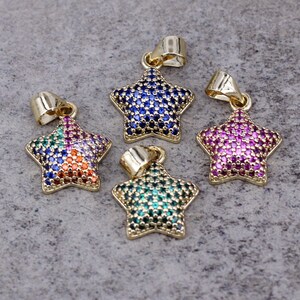 Puede incluir: Cuatro colgantes en forma de estrella de tono dorado con detalles de cristal de colores. Cada colgante presenta una combinación de colores diferente de cristales azules, verdes, rosas y naranjas.